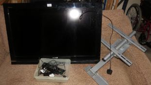 A Sony TV and wall mounted stand with remote and 2 Amazon firesticks