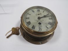 An eight day brass ships bulk head clock signed S. D Neill Belfast