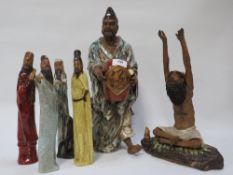 A collection of Asian figures to include a man carrying a vase A/F