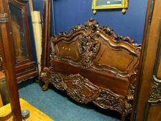 A large carved mahogany bedframe W 190 cm
