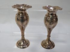A pair of hallmarked silver miniature vases with filled bases