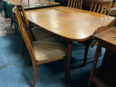 A mid century teak drawleaf dining table and four chairs