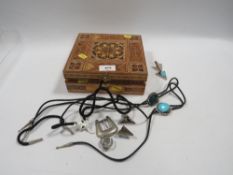 An inlaid box containing a collection of cowboy neckties, strapends etc
