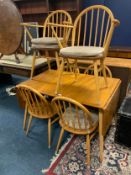 A mid- century Ercol Windsor dropleaf table with six chairs, in blonde / beech and elm