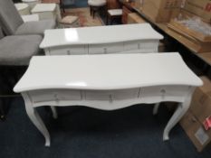 A pair of three drawer serpentine fronted console tables