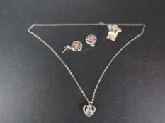 A silver necklace, earrings, large charm