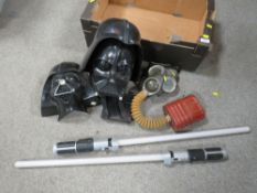 A tray of Darth Vader Star Wars masks plus a lightsaber