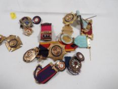 A collection of enamel badges and medals to include oddfellows, forsters, buffs etc
