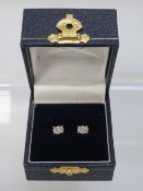 A pair of oval earrings set in unmarked white metal