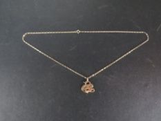 An unmarked yellow metal pendant on a 9ct gold chain approx weight of chain 1.7g