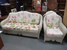 A six piece painted wicker conservatory suite, comprising a 2/3 seater sofa, two chairs, a footstool