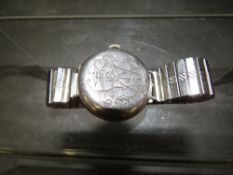A vintage silver trench watch with engraved push button sprung cover on expandable steel bracelet