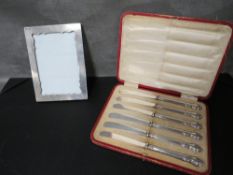 A hallmarked silver photo frame together with a cased set of 6 hallmarked silver handled knives