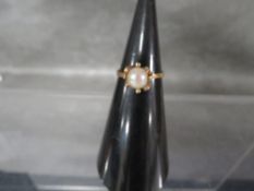 An unmarked yellow metal ring set with a cultured pearl approx weight 2.3g