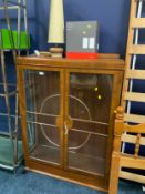 A vintage walnut display cabinet with lamps