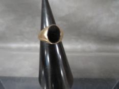 A hallmarked 9 carat gold signet ring set with a black stone approx weight 8.6g