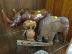 Four carved African themed items to include a large rhino