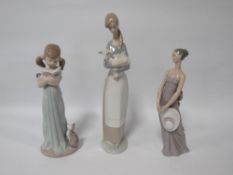 Three Lladro figurines to include a girl holding a kitten