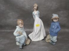 Three assorted Nao figurines to include a boy holding a rabbit