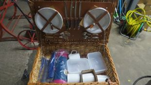 A wicker picnic basket complete with contents
