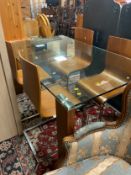 A modern glass top dining table with four chairs