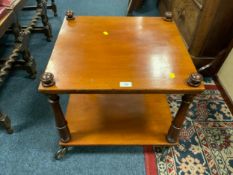 An antique mahogany two-tier table on castors