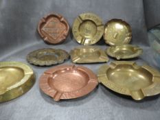A collection of antique advertising brass and copper ashtrays