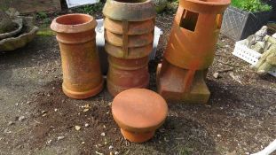 A selection of three terracotta chimney pots and cover