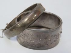 A hallmarked silver bangle together with a white metal example