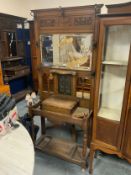 An Art Nouveau carved oak hall stand with copper plaque