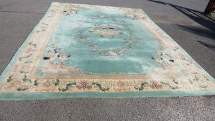 A large Oriental woollen Chinese rug, in green and cream with crane birds pattern