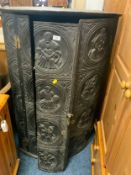 An antique carved oak corner cupboard. S/D