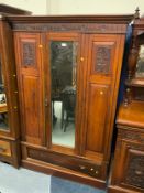 An antique mahogany carved mirrored wardrobe