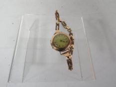 A 9ct gold watch on an expandable bracelet