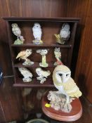 A collection of owl figurines to include a large owl on a plinth
