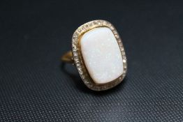 AN 18CT OPAL AND DIAMOND RING, the squared oval opal measuring approx 2 cm by 1.25 cm and surrounded
