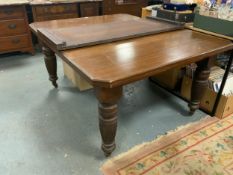 An Edwardian extending oak dining table with one extra leaf
