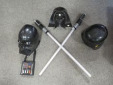 A tray of Darth Vader Star Wars masks plus a lightsaber