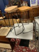 A modern bistro style table and two stools