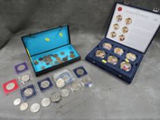 A box of coins to include a US dollar coin money clip and a cased set of Diamond Jubilee coins