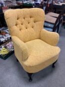 A modern yellow upholstered armchair