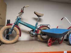 Three child's toys to include a tricycle, wheelbarrow and a Prima bike