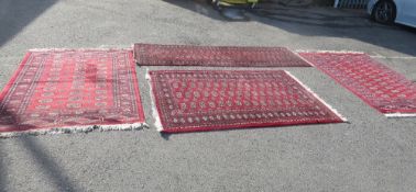 A selection of four rugs, in red colorways and patterns made by Frith and Kiran carpets (4)