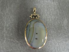 A HALLMARKED 9 CARAT GOLD MOUNTED POLISHED HARDSTONE PENDANT, with contrasting colours on each side,