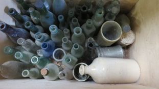 A wooden chest and contents of antique bottles
