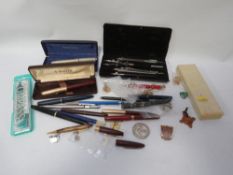 A quantity of vintage pens, badges etc