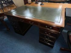 A modern mahogany green leather topped twin pedestal desk