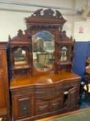 A large antique mahogany carved mirror back sideboard