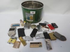 A tin of assorted cigarette lighters etc