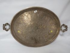 A large antique Anglo- Indian brass serving tray with peacock handles and engraved decoration of